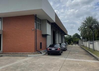 Front view of a building with a driveway and parked cars