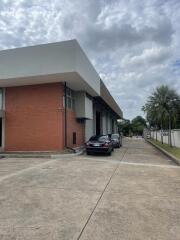 Front view of a building with a driveway and parked cars