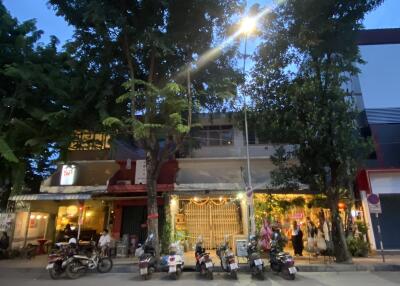 Street view of a building with shops and parked motorbikes