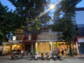 Street view of a building with shops and parked motorbikes