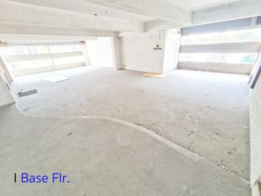 Open basement floor with concrete flooring and large garage doors