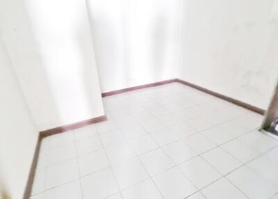 Empty tiled room with white walls