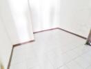 Empty tiled room with white walls