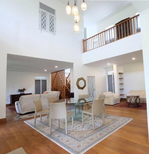 Spacious two-story living room with modern furniture and high ceiling