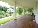 Spacious veranda with wooden flooring and a view of a lush garden