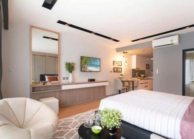 Modern bedroom with a cozy seating arrangement, integrated kitchenette, and stylish decor