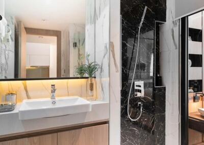 Modern bathroom with sink, large mirror, shower area, and contemporary design