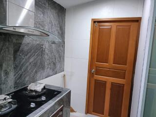 Modern kitchen with wooden door and stove