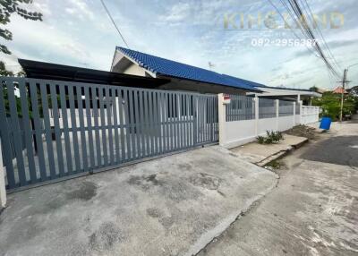 Gated property with blue roof and white fence