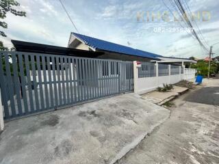 Gated property with blue roof and white fence