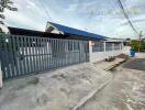 Gated property with blue roof and white fence