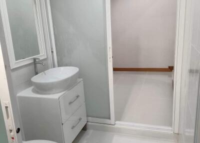 Modern bathroom with white fixtures and frosted glass door