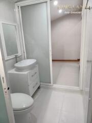 Modern bathroom with white fixtures and frosted glass door