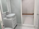 Modern bathroom with white fixtures and frosted glass door