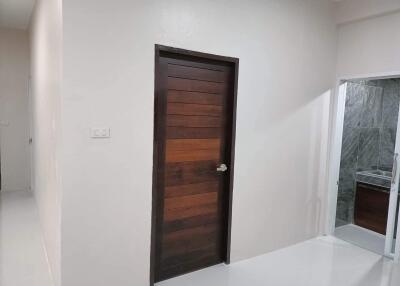 Modern hallway with wooden door and adjacent bathroom