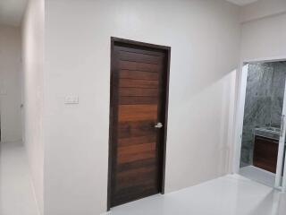 Modern hallway with wooden door and adjacent bathroom