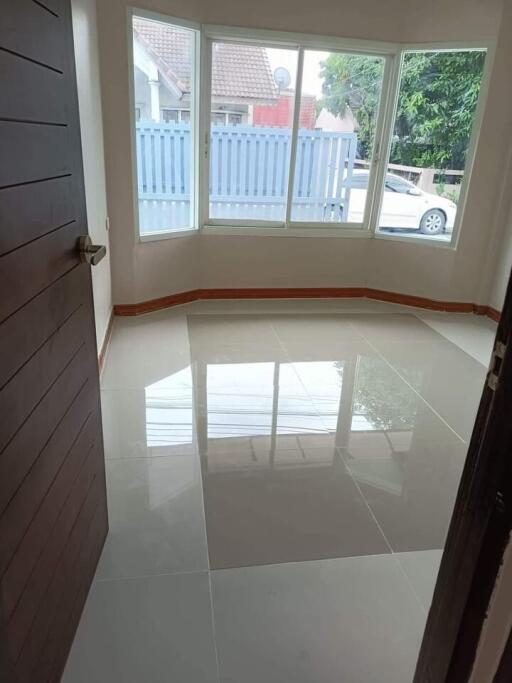 Empty room with large window and tiled flooring