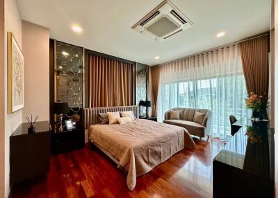 Elegant bedroom with wood flooring, large window and modern decor