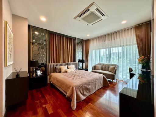 Elegant bedroom with wood flooring, large window and modern decor