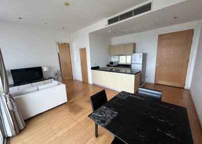 Modern open-plan living room and kitchen area with a seating area and dining table