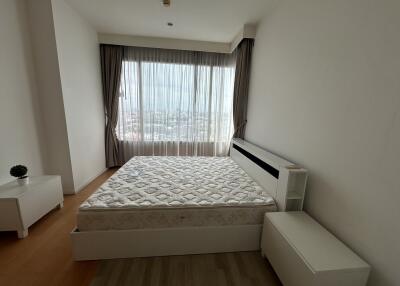 Bedroom with a large window and bed