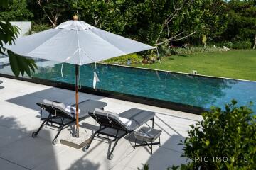 Outdoor pool area with lounge chairs and umbrella