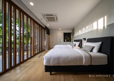 Spacious modern bedroom with large windows and twin beds