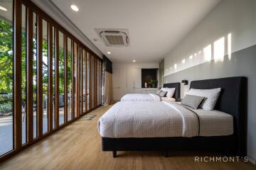 Spacious modern bedroom with large windows and twin beds