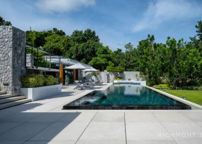 Modern outdoor pool area with surrounding greenery