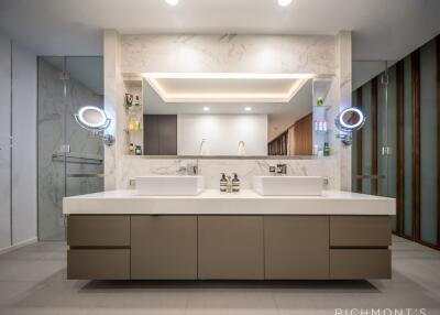 Modern bathroom with dual sink vanity and illuminated mirrors