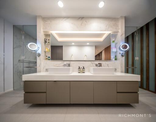 Modern bathroom with dual sink vanity and illuminated mirrors