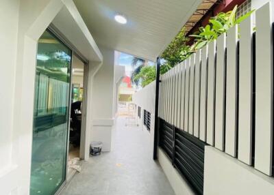 Outdoor corridor with a sliding glass door and modern fence