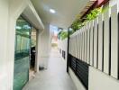 Outdoor corridor with a sliding glass door and modern fence