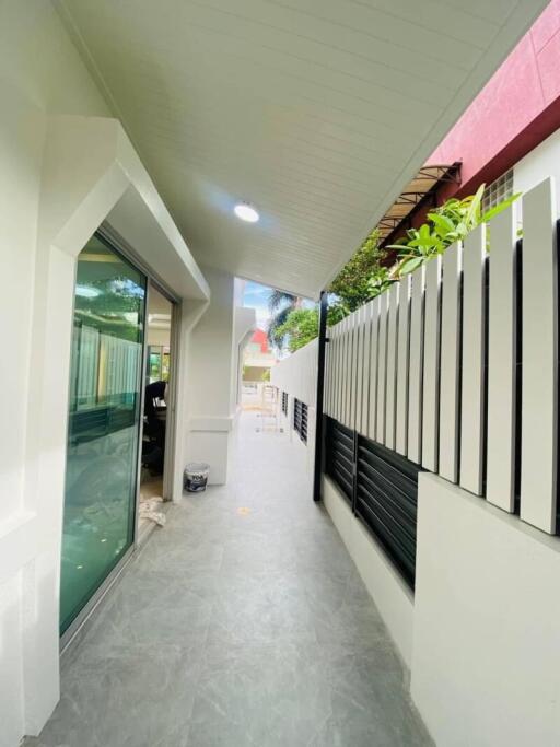 Outdoor corridor with a sliding glass door and modern fence