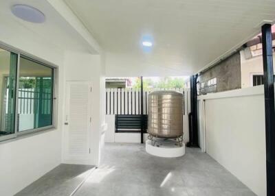 Outdoor patio area with tiled floor and water tank