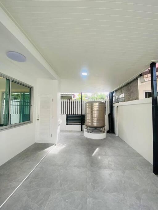 Outdoor patio area with tiled floor and water tank