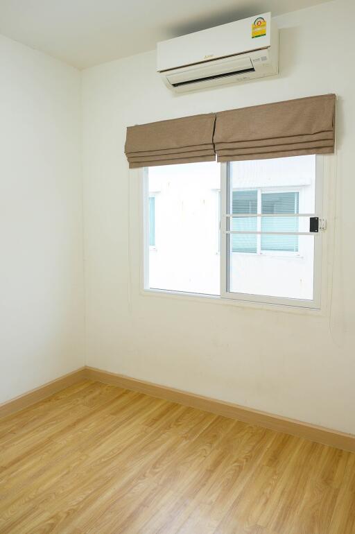 Empty bedroom with wooden floor and air conditioning unit