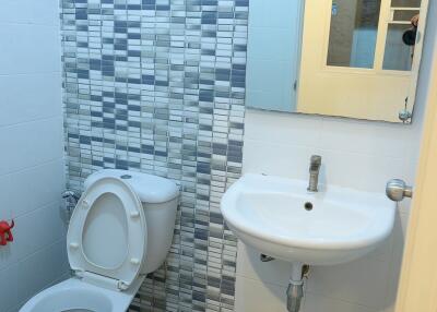 Bathroom with toilet, sink, and mirror