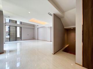 Spacious modern living room with large windows and stairs