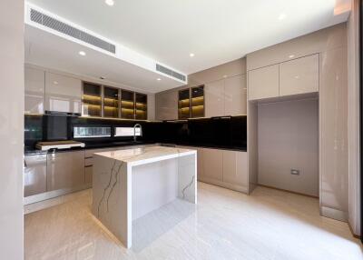 Modern kitchen with island, marble countertop, and under-cabinet lighting