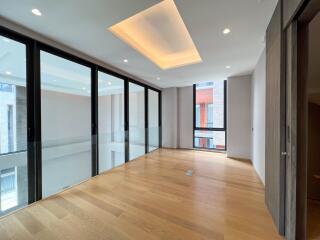 Spacious living area with wooden flooring and large windows