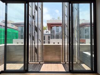 Modern balcony with large glass sliding doors and a view of neighboring buildings