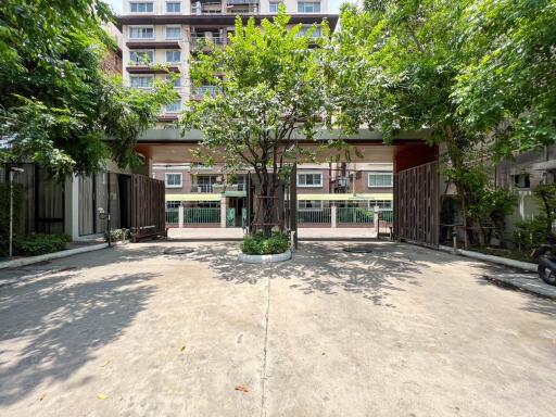 Main entrance to a modern residential building with lush greenery