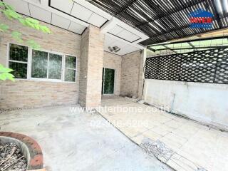 Outdoor patio with brick walls and overhead lattice structure