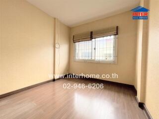 Unfurnished bedroom with wooden flooring and two windows