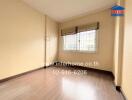 Unfurnished bedroom with wooden flooring and two windows