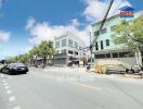 Street view featuring buildings and cars, with a real estate advertisement