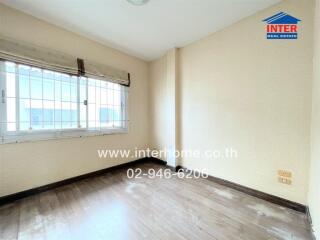 Bedroom with large window and wooden floor