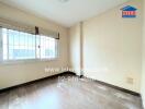 Bedroom with large window and wooden floor