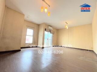 Spacious living room with hardwood floors and large windows.